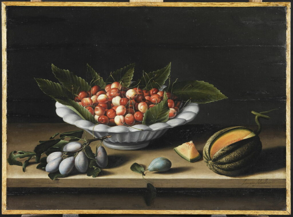 A rectangular, landscape mode painting of red and/or white cherries nestled among large green leaves in a ceramic white bowl. The bowl sits on a wooden tabletop; in front of it is branch of about 6 plums on a branch; to the right of the branch is a single plum, and further to the right is an oblong green melon. A chunk is cut out of the melon to show the orange flesh.
