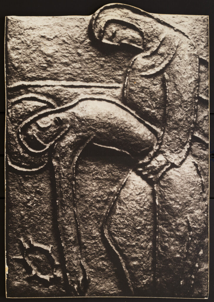 Bas relief sculpture of a human figure to the viewer's right, holding at the waist the figure of the haloed Christ, presumably dead, leaning away to the viewer's left.