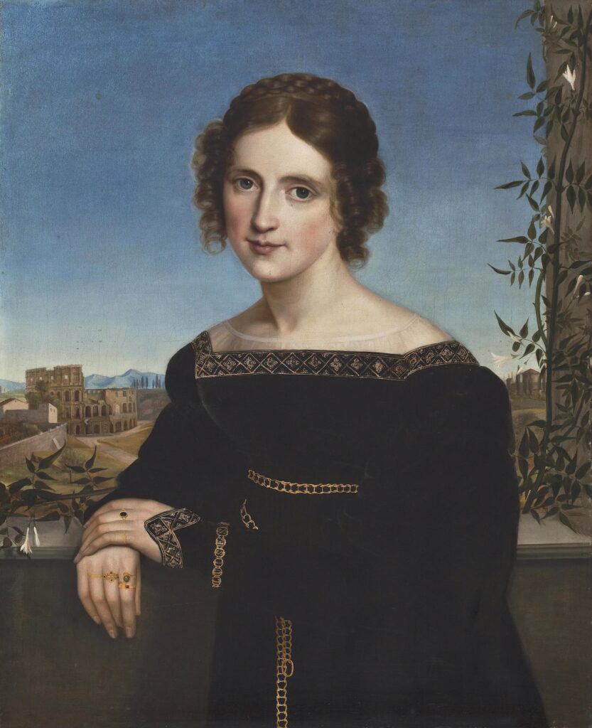 A half-length portrait of a dark hair woman in a black dress with gold trip, standing against the outer edge of a balcony. Her left arm is bent, with her arm positioned across her body so that her left hand can sit on top of her right hand, which rests on the balcony wall. In the background is a landscape with classical ruins.